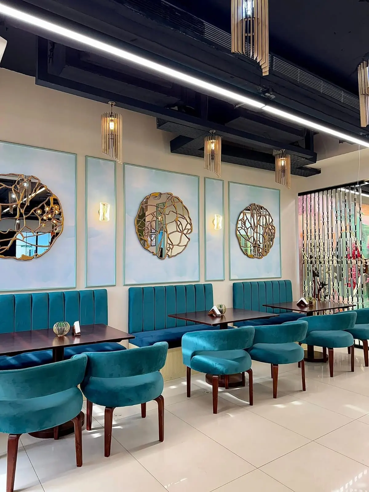Teal banquette seating and gold mirror wall